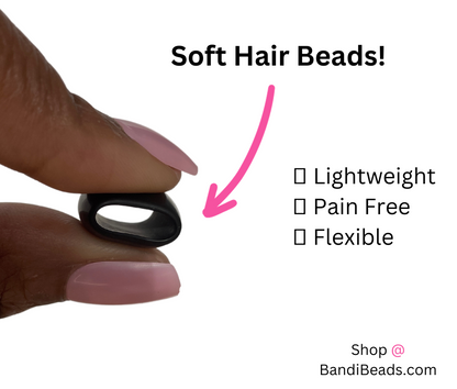 black silicone rubber hair bead pressed between two fingers for demonstration to show that the beads are soft hair beads
